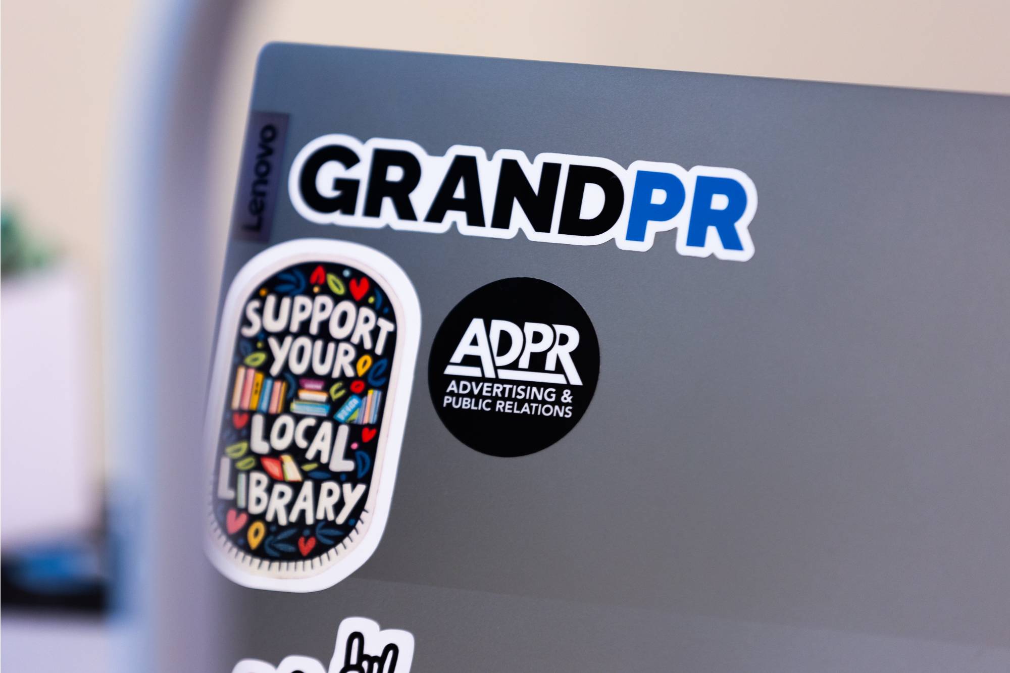 Close up of a laptop sticker that says "GrandPR"